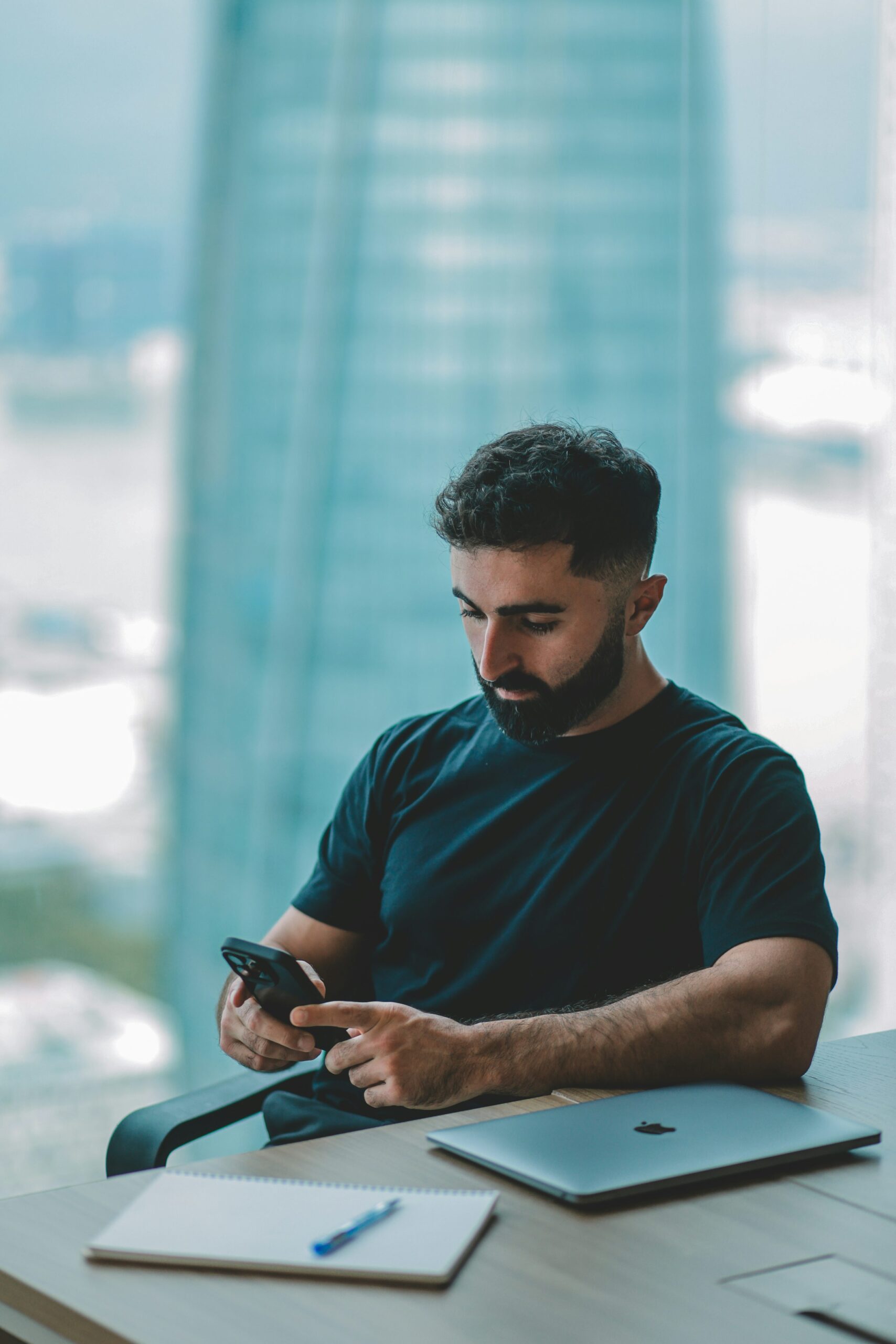 Man using smartphone and laptop for budgeting and personal finance management
