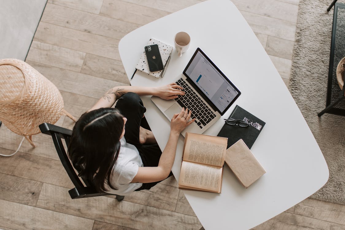 Young woman using a laptop and phone to manage finances and budgeting with AI tools